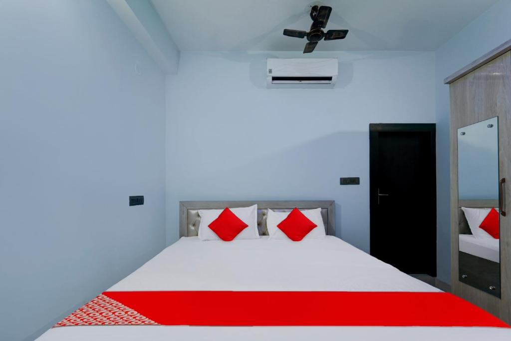 a bedroom with a white bed with red pillows at Hotel O J.T. Residency in Rānchī