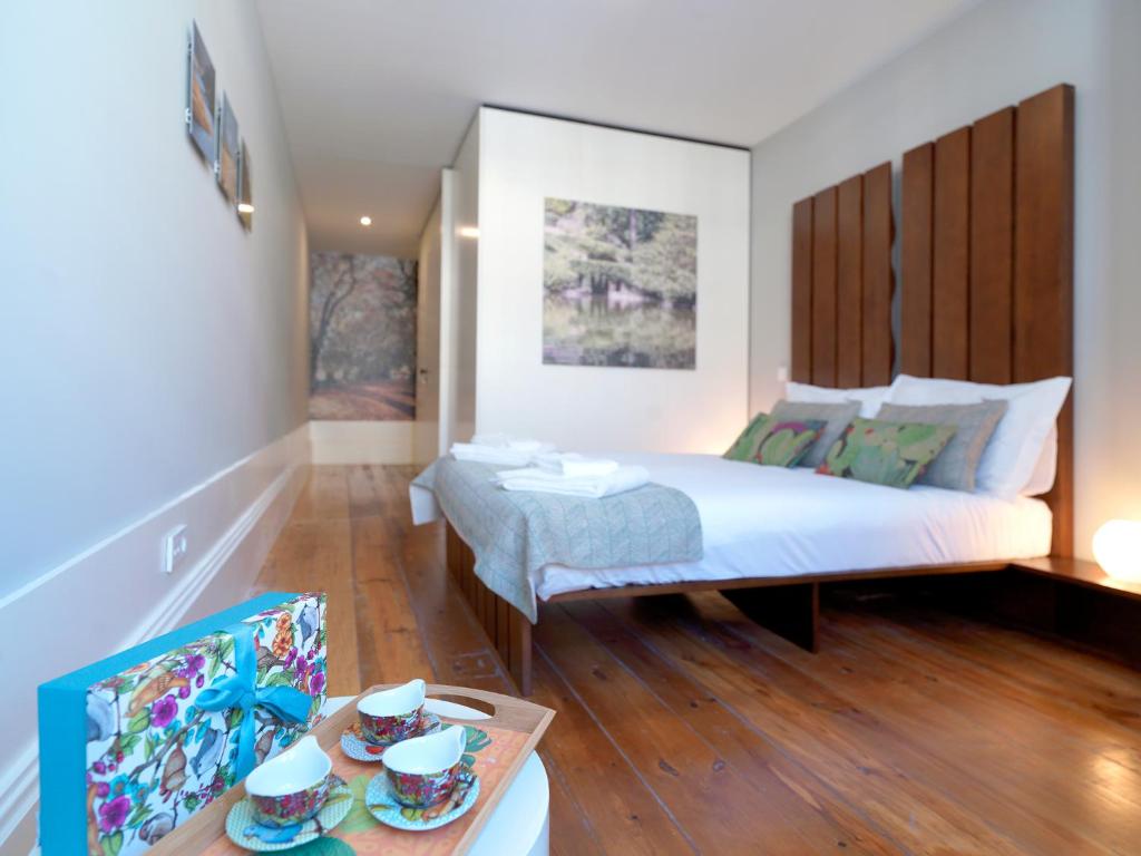 ポルトにあるFLH Porto Portuguese Apartmentsのベッドルーム1室(ベッド1台、テーブル、食べ物付)