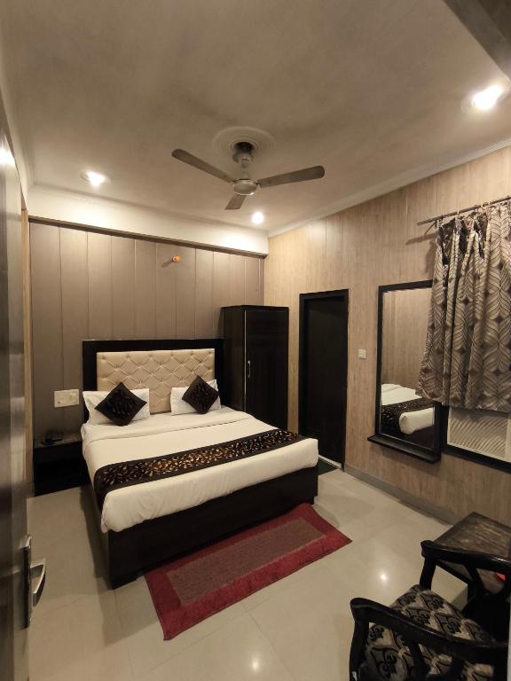 a bedroom with a large bed and a mirror at Hotel Aashray in Haridwār