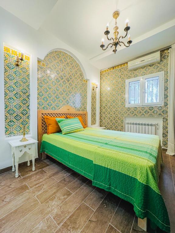 a bedroom with a bed and a chandelier at La Maison de haut in Tunis
