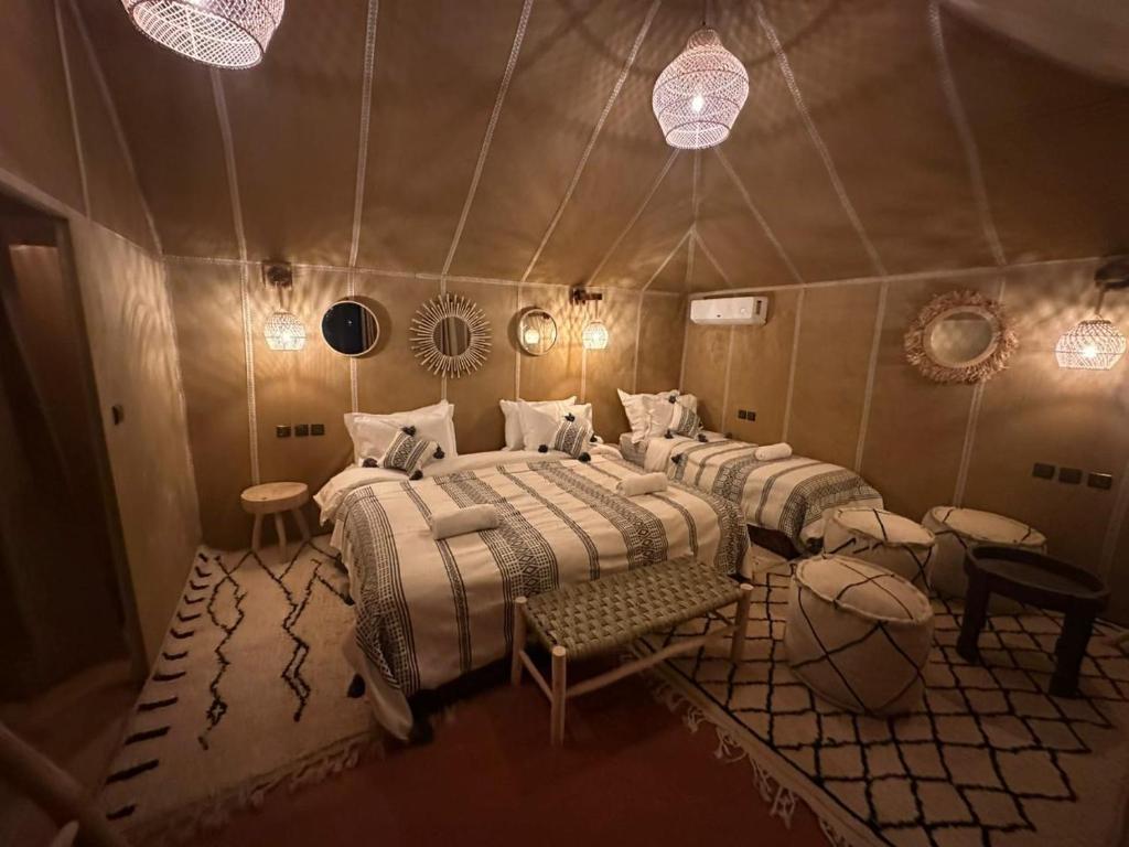 a room with four beds in a tent at ChariF Luxury Camp in Rissani