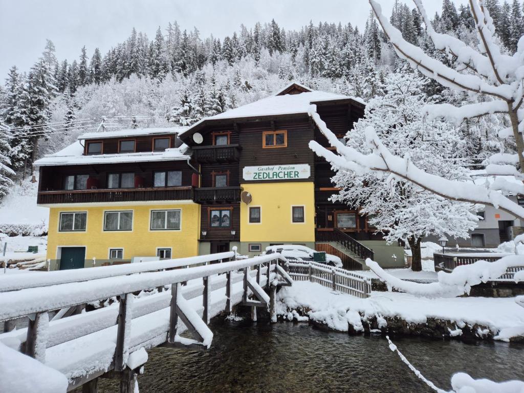 a building covered in snow next to a bridge at Haus Zedlacher in Patergassen