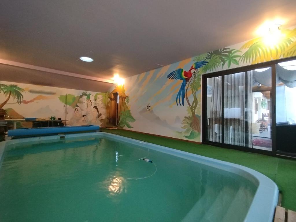 a swimming pool in a house with a mural at chambres d hôtes chez Isabelle in La Ferté-Saint-Cyr