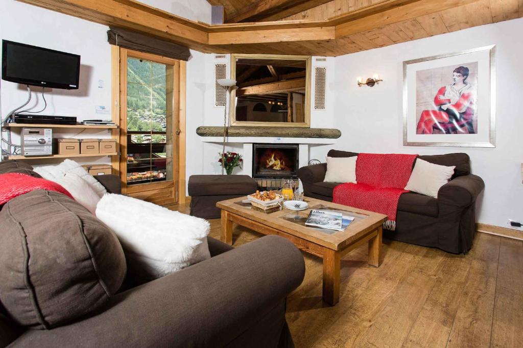 a living room with two couches and a coffee table at Les Pelerins Apartment - Chamonix All Year in Chamonix