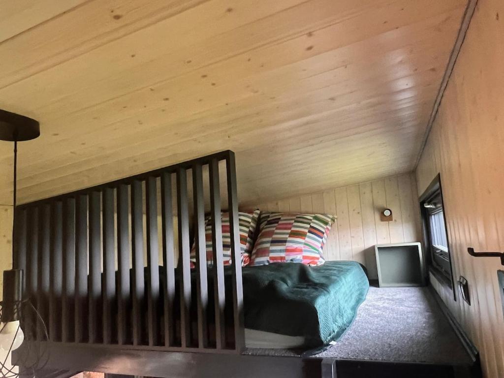 a bed in a room with a wooden ceiling at tiny house Eisingen in Eisingen