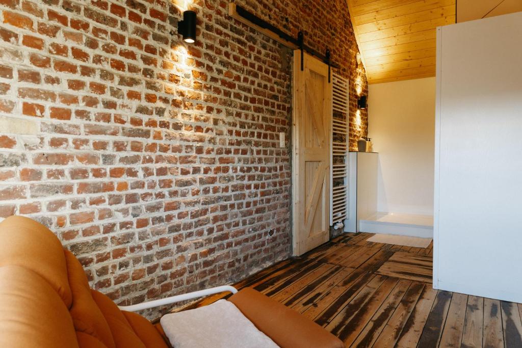 a living room with a brick wall and a couch at vakantiewoning 't Rijhuys in Diksmuide