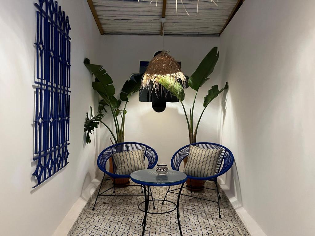 a dining room with two chairs and a table at Riad house Lyabaïana,piscine climatisation, hammam, vue mer in Tangier