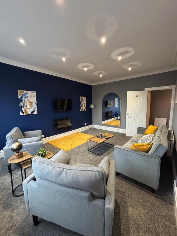 サンダーランドにあるAffordable Luxury 2 Stunning apartment Sunderland close to City centre hospital Crown Works Studio and Nissanの青い壁のリビングルーム(ソファ2台付)