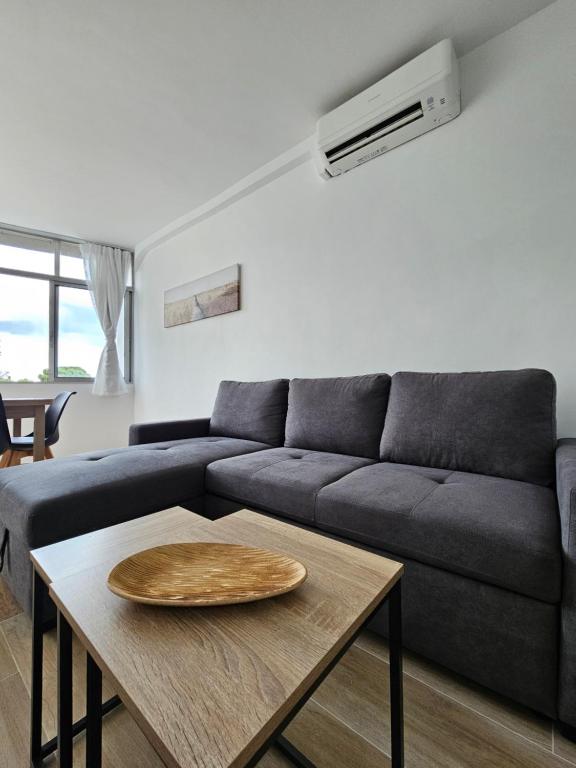 a living room with a couch and a table at Modern Duplex Studio with BBQ in Molnás
