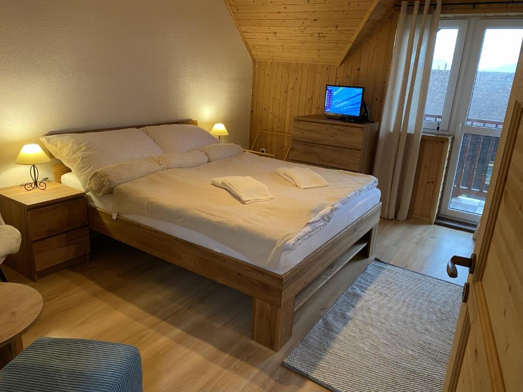 a bedroom with a large bed with a television on it at Pension Harmony in Liptovský Michal