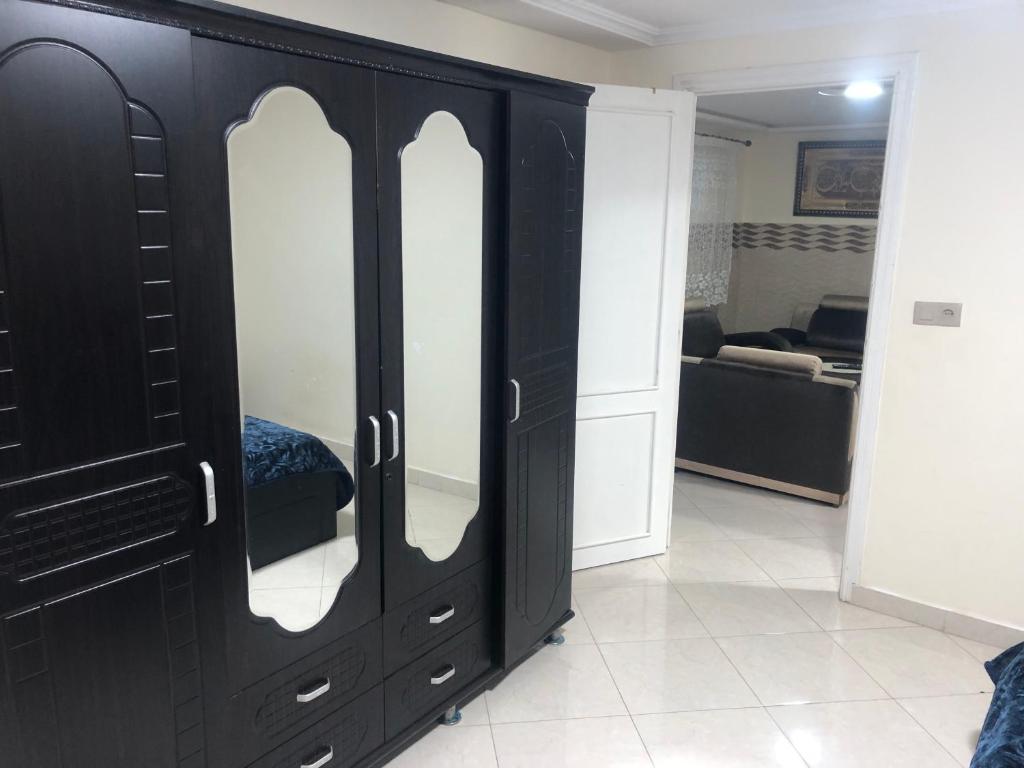d'une armoire noire avec des portes en verre dans le salon. dans l'établissement شقة للكراء اليومي, à Segangane