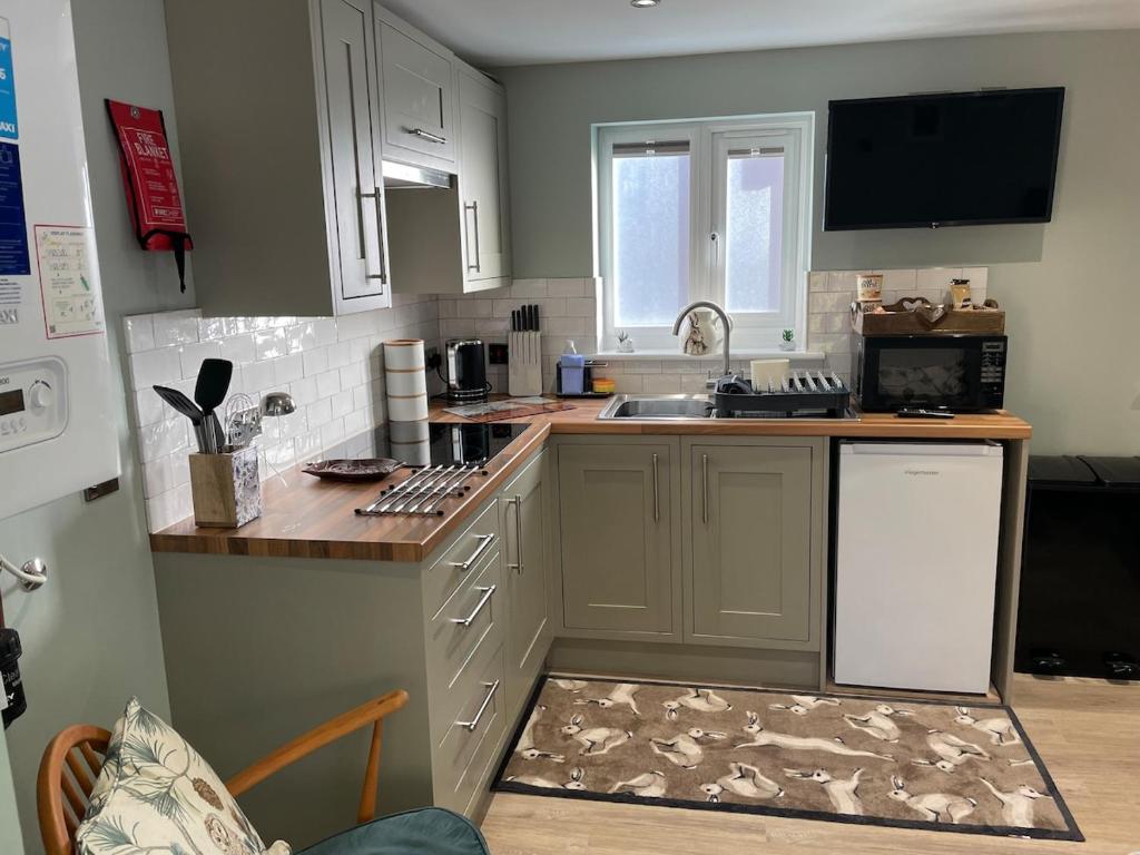 a kitchen with white cabinets and a counter top at Woodland View in East Harling