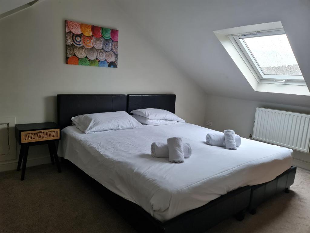 a bedroom with a large bed with towels on it at Swindon City Centre Duplex - EnterCloud9SA in Swindon