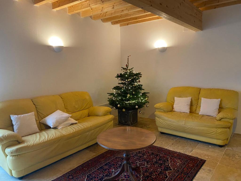 a living room with a couch and a christmas tree at Forest House by Lake Pannecière in Chaumard