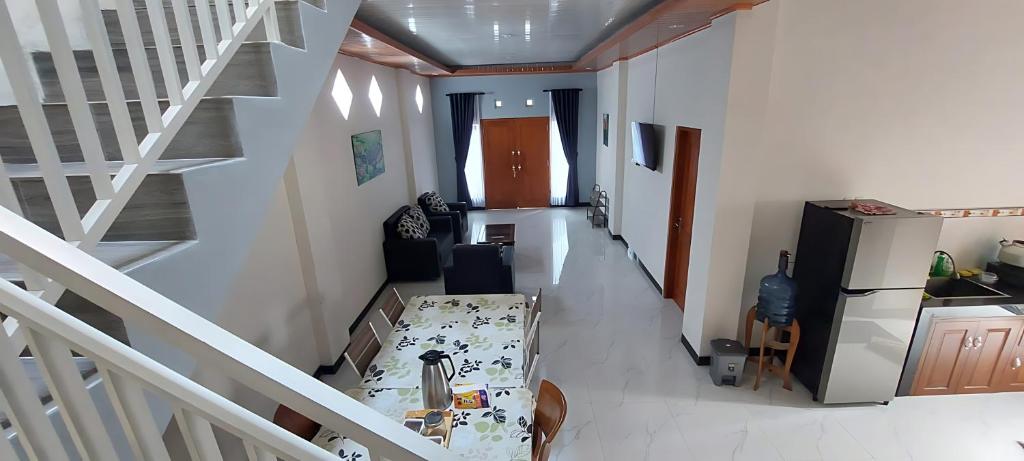 Habitación con escalera y sala de estar con mesa. en Mentari Homestay, en Sentool