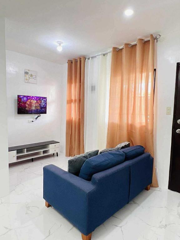 a blue couch in a living room with a tv at JMary Stayhouse in Nopol