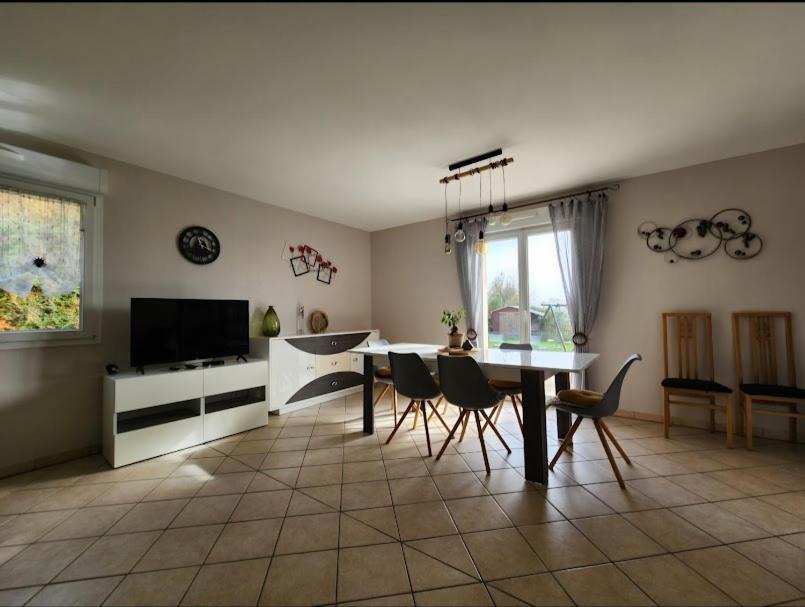a living room with a table and chairs and a television at maison in Le Thillot