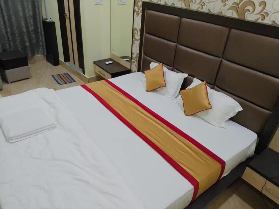 ein Schlafzimmer mit einem großen Bett mit zwei Kissen in der Unterkunft Hotel Kalita Palace in Sibsāgar