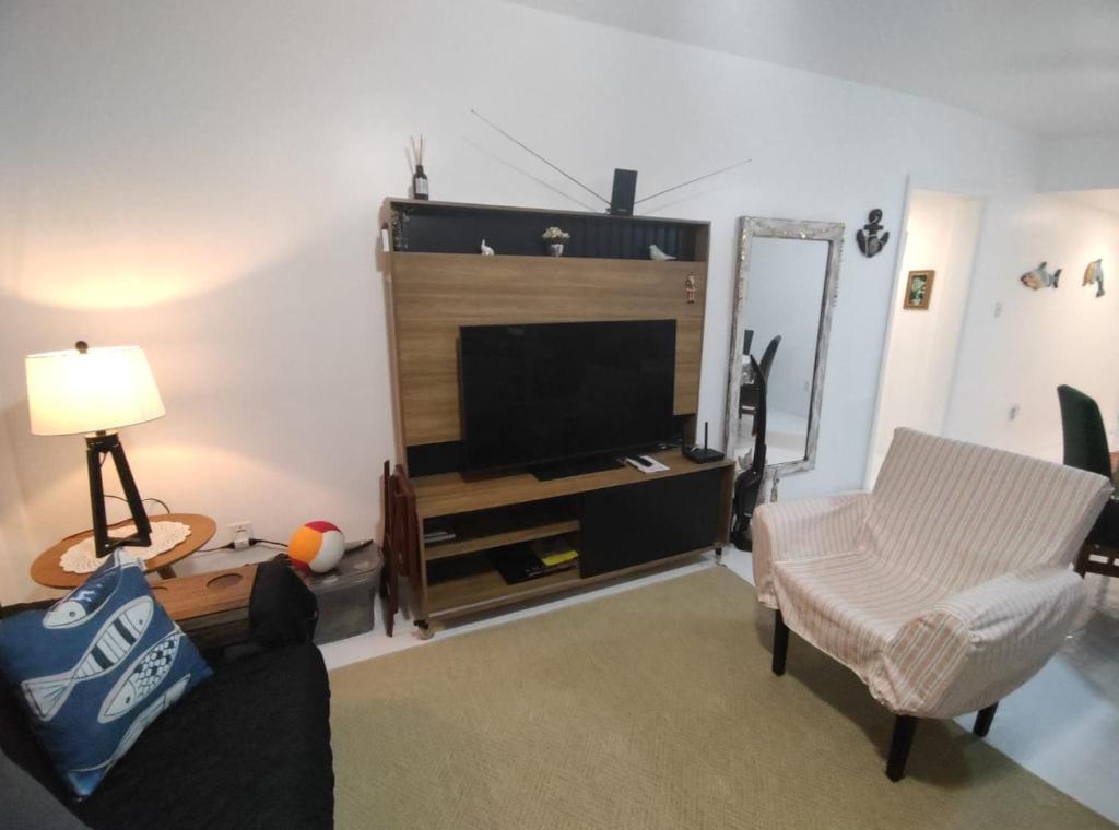 a living room with a tv and a couch and a chair at Mariechen 603, Perfeito, Central in Torres