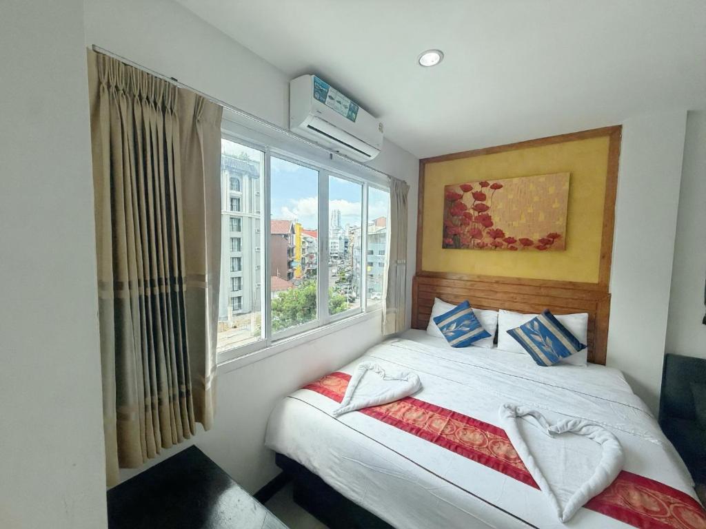 a bedroom with a bed and a large window at Abby's House Hotel in Patong Beach
