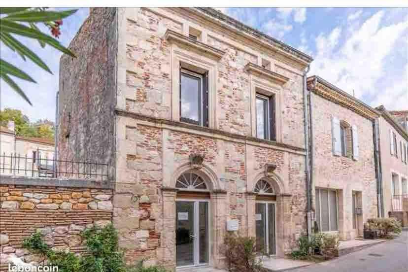 an old stone house with a brick building at Village house in Penne-dʼAgenais