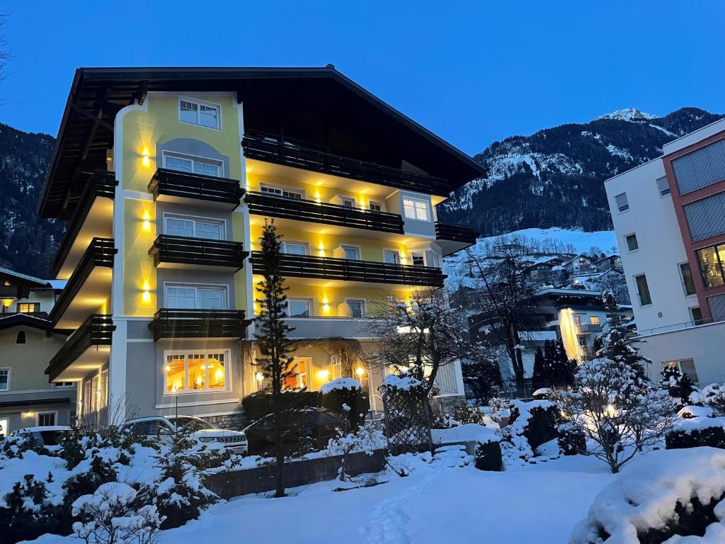 ein Gebäude mit eingeschalteten Lichtern im Schnee in der Unterkunft mühlbacher - inklusive kostenfreiem Eintritt in die Alpentherme in Bad Hofgastein