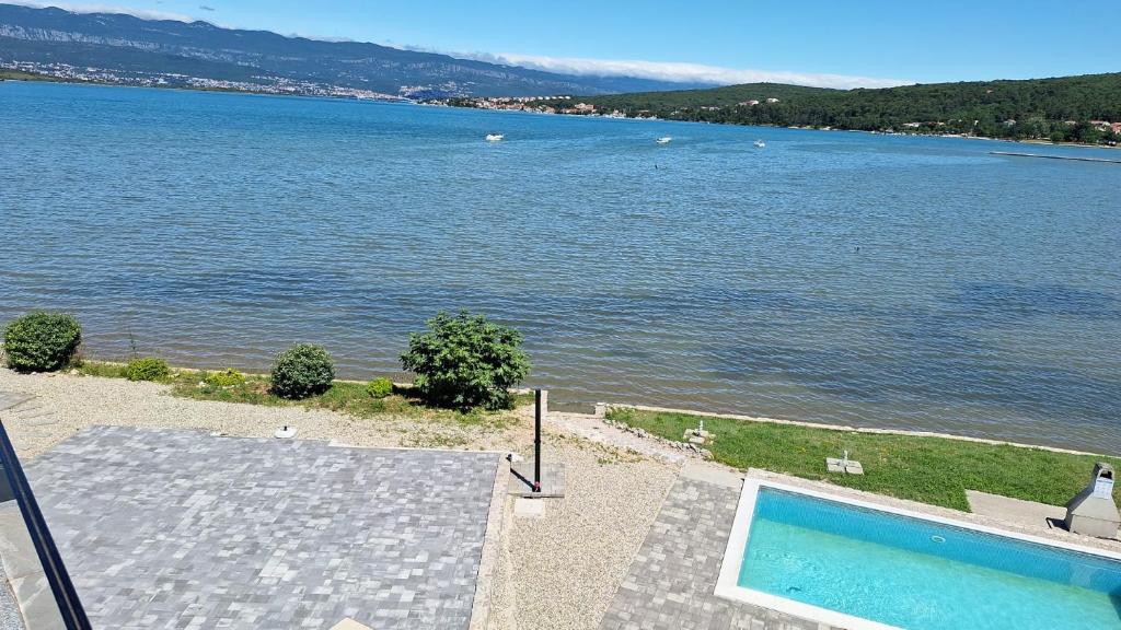 een uitzicht op een waterlichaam met een zwembad bij Penthouse Dream Vista in Čižići