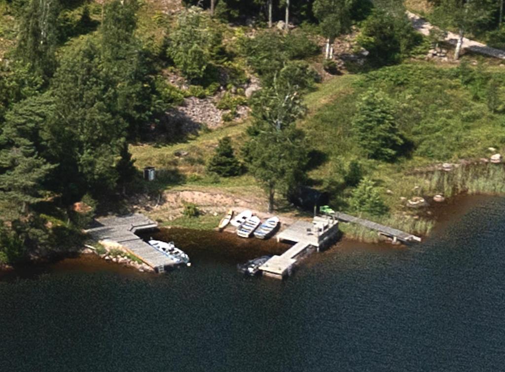 an aerial view of a dock with boats in the water at Accommodation near lake and forest including rowing boat in Tranås