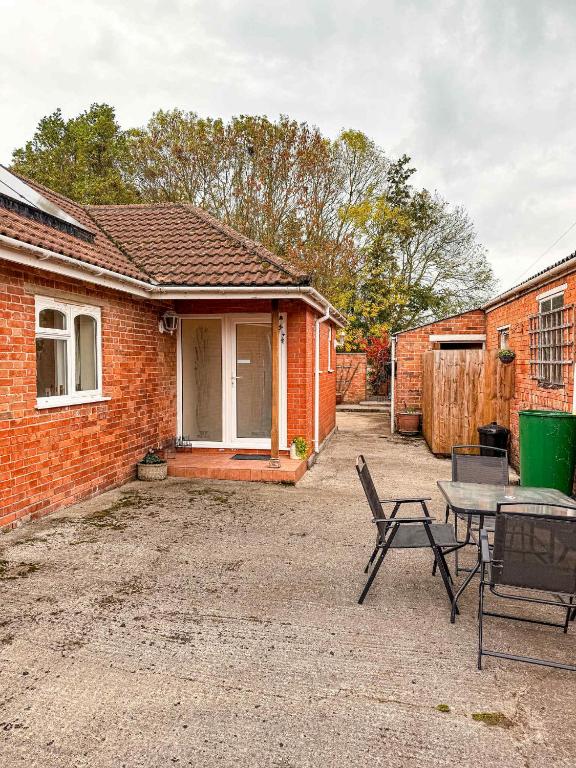 a brick house with a table and chairs in front of it at Three Bedroom Bungalow ideal for families or contractors Highbridge in Highbridge