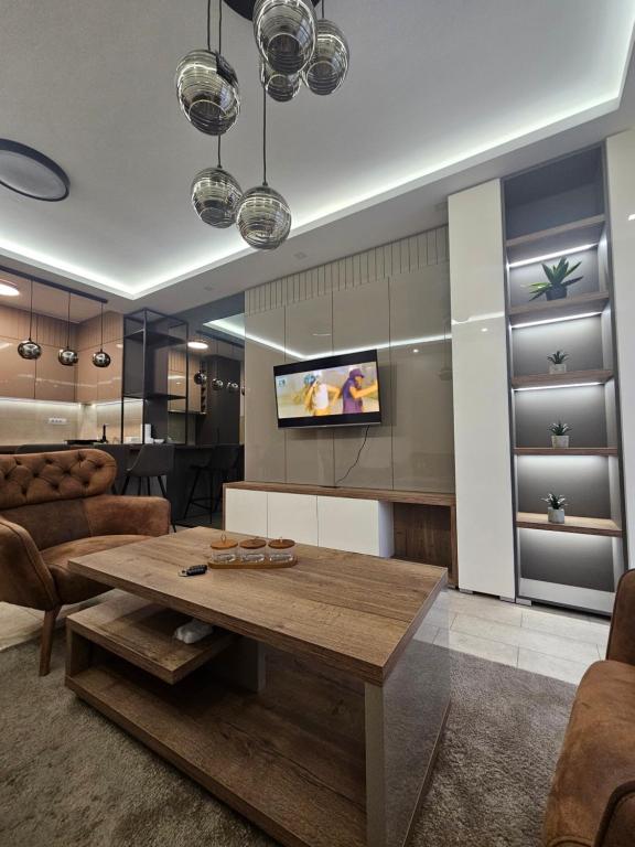a living room with a table and a tv at Miss Extra LuX in Mladenovac