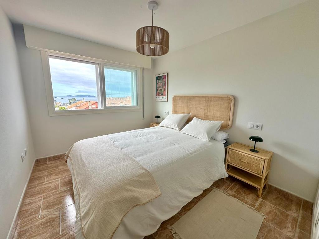 a bedroom with a large bed and a window at Apartamento Balea - San Vicente do Mar in Balea