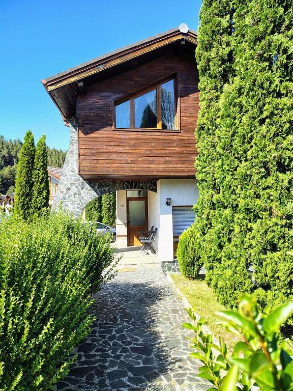a house with a wooden roof and a driveway at Fairytale Cottage in Redenka in Razlog
