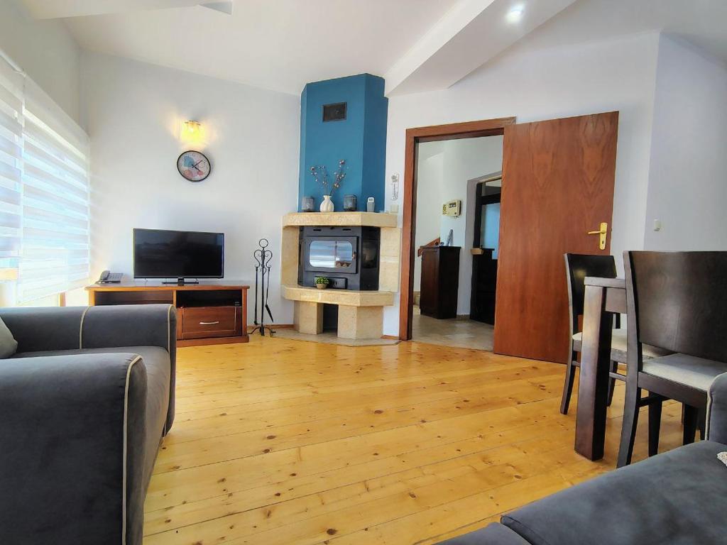 ein Wohnzimmer mit Sofa und Fernseher in der Unterkunft Fairytale Cottage in Redenka in Raslog