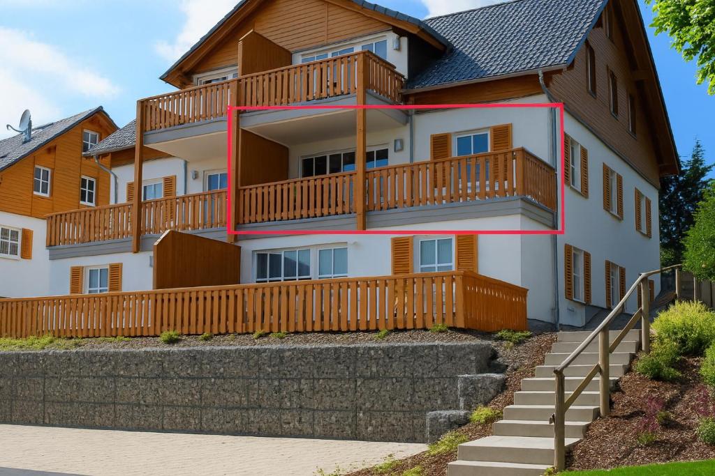 a large house with wooden balconies and stairs at Haus Waldblick in Winterberg