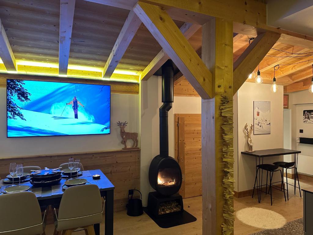 モントリオンにあるPortes du Soleil T3 "comme un chalet" direct access Morzine Avoriazのリビングルーム(テレビ、テーブル、暖炉付)