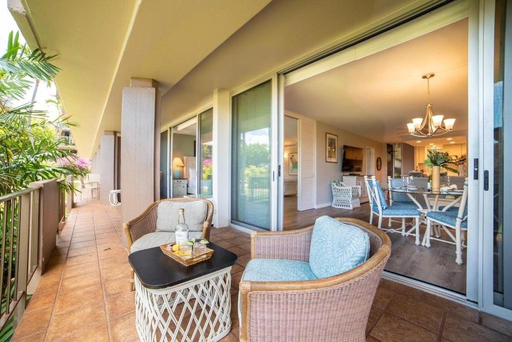 a patio with wicker chairs and a table on a porch at Eldorado E104 · Spacious 1BD wPool at Kaanapali in Kahana