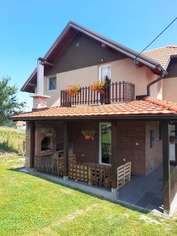 a house with a deck with flowers on it at Apartmani Rajić, Tara in Kaludjerske Bare