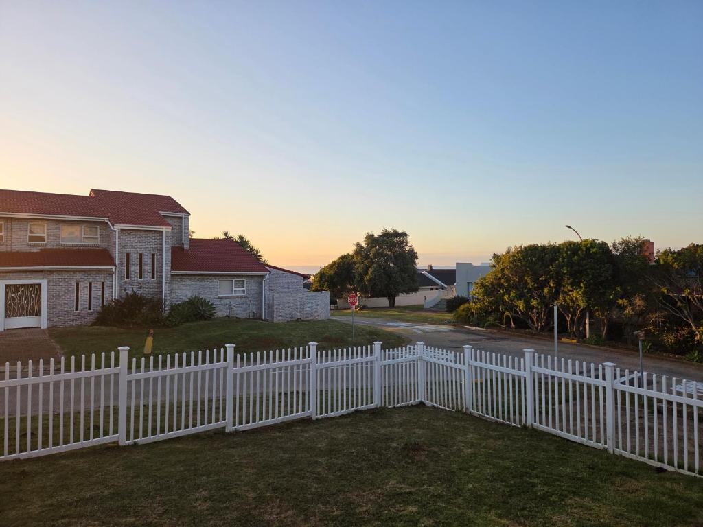 a white picket fence in front of a house at BushWave in Jeffreys Bay