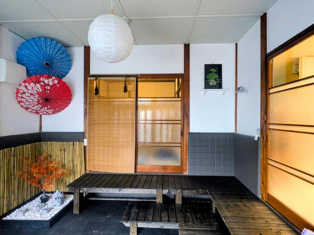 a room with a bench and umbrellas on the wall at サマサマアイル saMa-saMa Aisle in Odawara