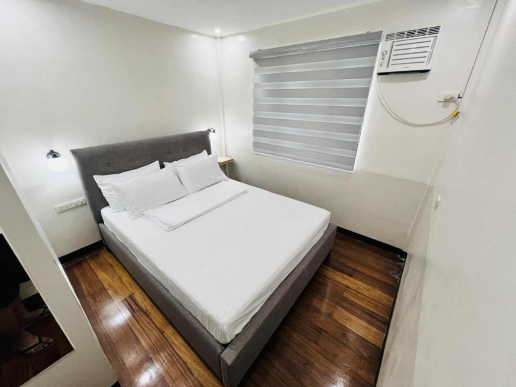 a small bedroom with a white bed and a window at Layover at 1146 in Manila
