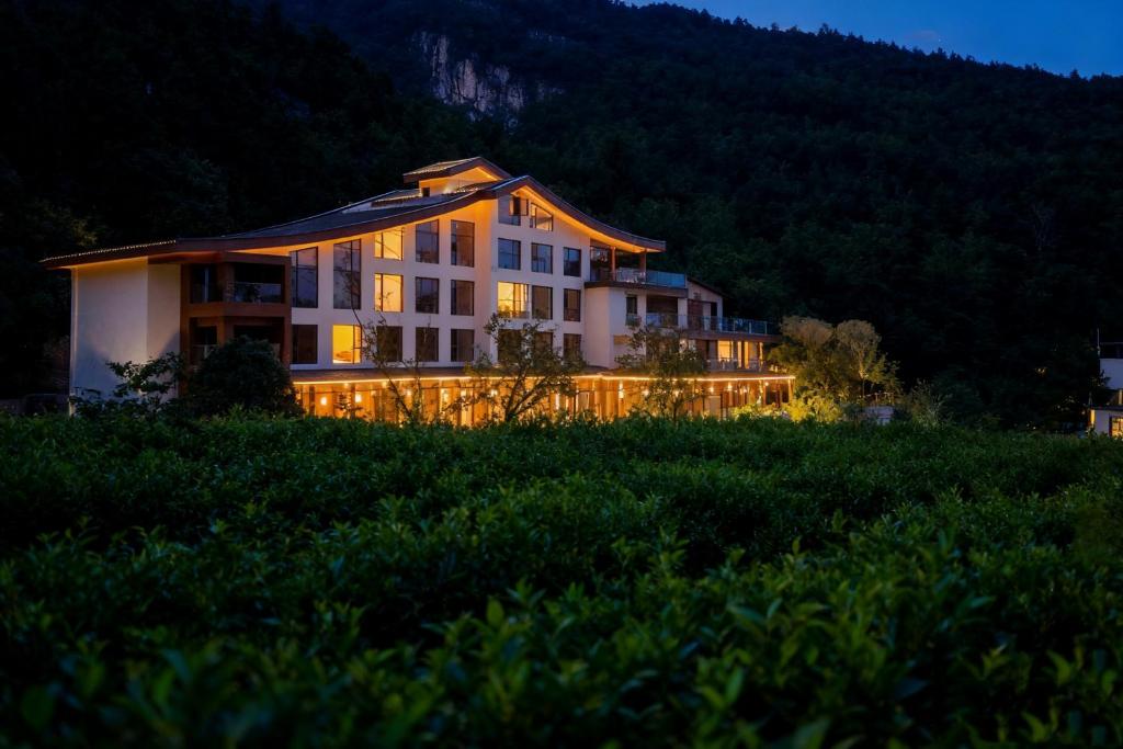 a large building with lights in a field at 重庆金佛山古核隐庐Resort Hotel in Nanchuan