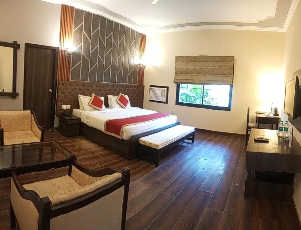 a bedroom with a bed and a couch and a table at Shani Vilas Ranthambore in Sawāi Mādhopur