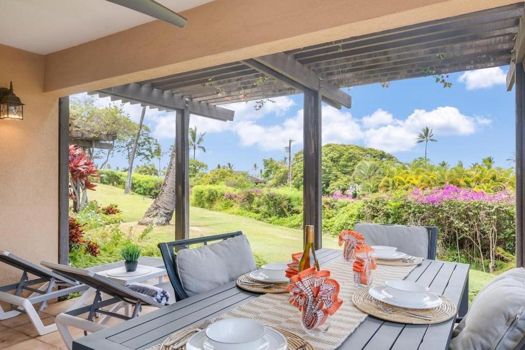 a dining table with a view of the garden at Wailea Ekahi 21A · WEK 21A Remodeled Wailea Condo Pool AC Near B in Wailea