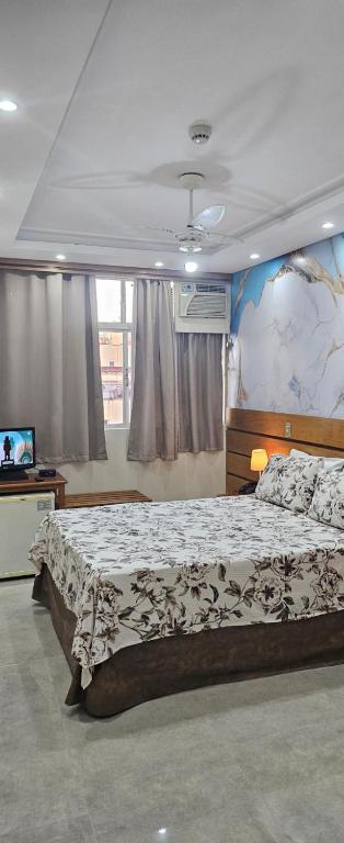 a bedroom with a large bed and a television at Dublin Hotel in São Paulo