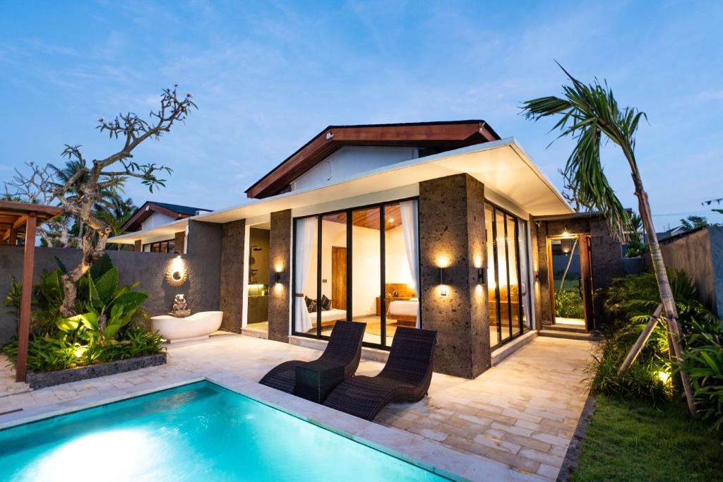 a villa with a swimming pool and a house at KAPI Sebatu Villa in Tampaksiring