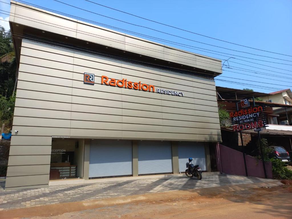 a building with a motorcycle parked in front of it at Radission in Padinjarathara