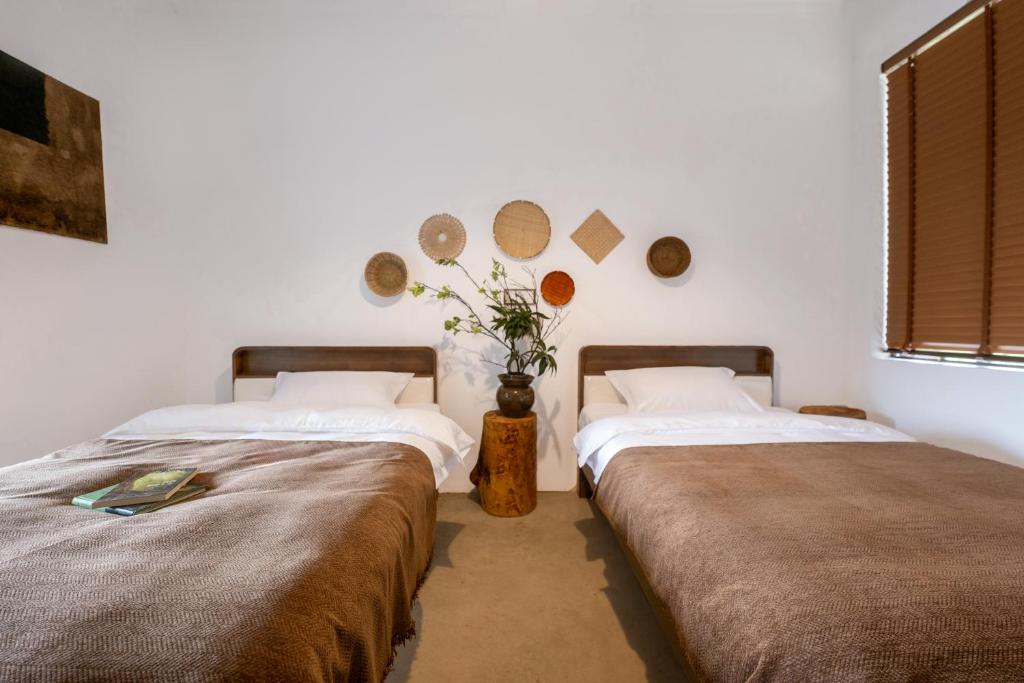 two beds sitting next to each other in a room at Xinwo Homestay in Pan-na-meng-hun