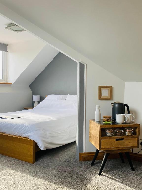a bedroom with a bed and a table with a mirror at Mooredge Guest House in Whitby