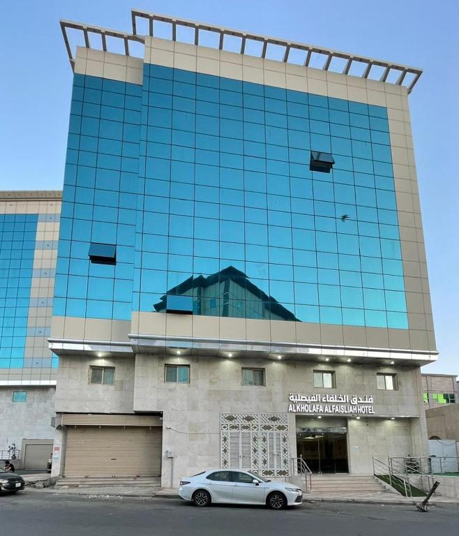 a building with a car parked in front of it at فندق الخلفاء الفيصلية الفندقية in Mecca