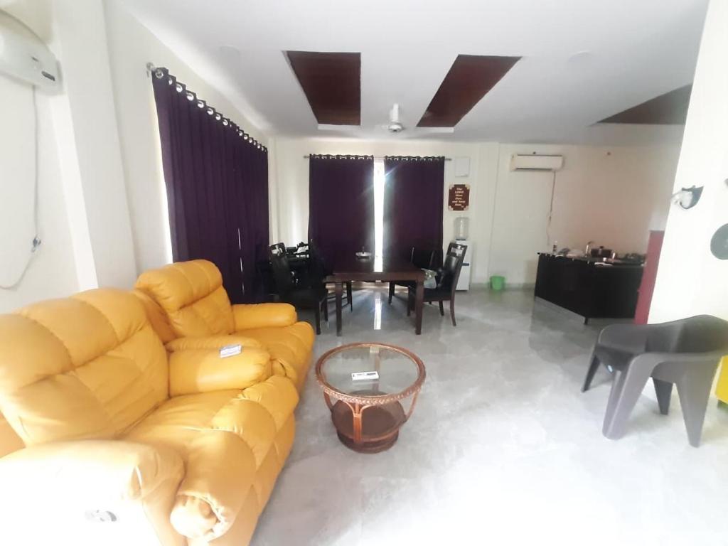 a living room with a couch and a table at SR Farm Stay in Turkapally